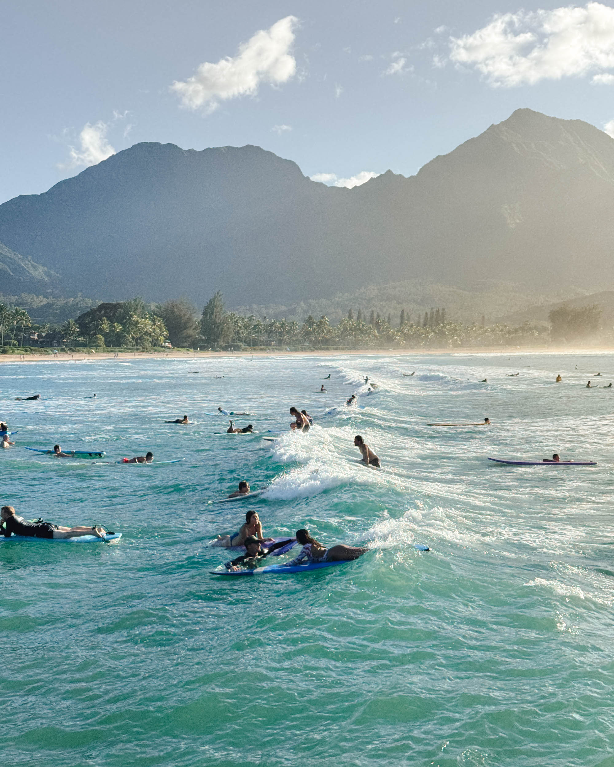 Surfers in hanalei bay kauai as seen from the pier